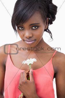 Woman holding daisy wearing pink dress