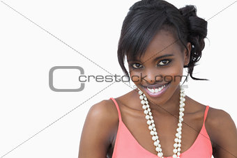 Woman standing wearing a pearl necklace smiling