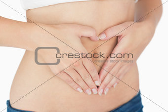 Woman making heart sign on belly