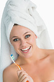 Happy woman with hair towel and her toothbrush
