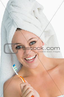 Happy woman with hair towel and her toothbrush