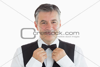 Waiter adjusting his own bow tie