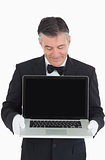 Happy waiter showing us something on a laptop