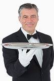 Smiling waiter holding a silver tray