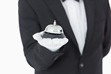 Well-dressed man holding a hotel bell