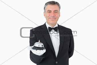 Man in suit holding hotel bell