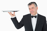 Well-dressed waiter holding a silver tray