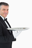 Waiter looking at camera while holding a silver tray