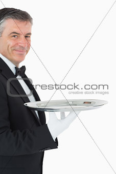 Waiter looking at camera while holding a silver tray