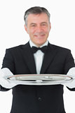 Waiter looking at the camera while holding a silver tray