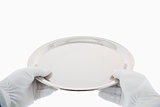 Gloved hands holding silver tray