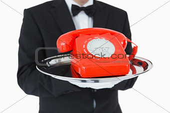 Red dial phone on a silver tray