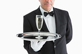 Man in suit serving glass with champagne