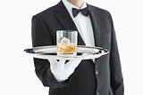 Man serving whiskey on tray