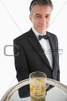 Man serving whiskey with ice on silver tray