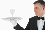 Man serving glass of wine on tray