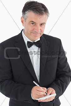Waiter writing orders and smiling