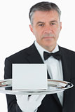 Man holding silver tray with white card