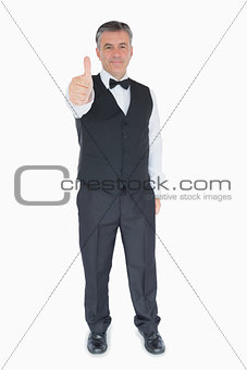 Smiling man in suit showing thumbs up
