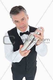 Waiter shaking drink in cocktail shaker