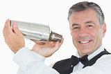 Happy waiter shaking drink in cocktail shaker