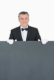Waiter standing behind grey sign