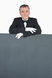 Man in suit leaning on grey board