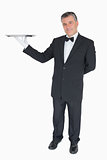 Smiling waiter holding empty tray
