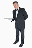 Waiter with his hand behind his back showing an empty tray