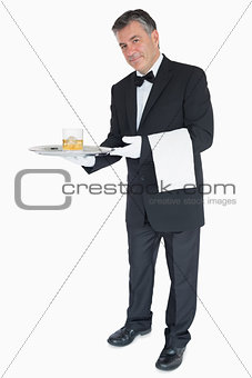 Waiter offering whiskey with ice