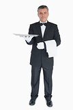 Smiling waiter holding out tray