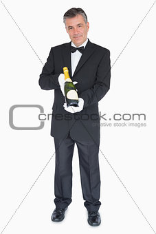 Waiter offering bottle of champagne