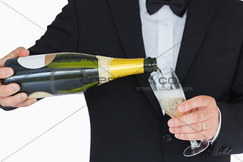 Well-dressed man pouring champagne
