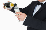 Man in suit pouring champagne