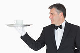 Waiter holding silver tray with cup