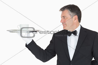 Waiter holding silver tray with cup