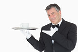 Waiter showing silver tray with cup