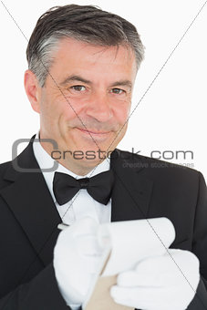 Waiter looking into the camera while is writing into the notebook