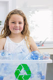 Little girl carrying box full of empty plastic bottles