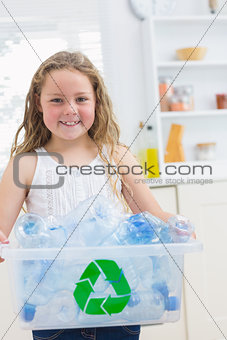 Smiling girl carrying box of the bottles