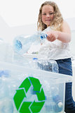 Girl throwing bottles into recycling box
