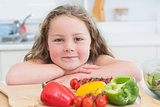 Girl leaning beside vegetables