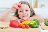 Little girl holding up cherry tomato