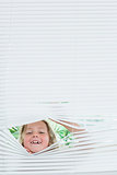 Girl peeking out of blinds