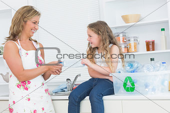 Mother sorting plastics waste with her daughter