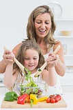 Mother and daughter mixing salad