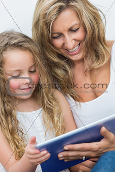 Mother and daughter having fun with tablet computer