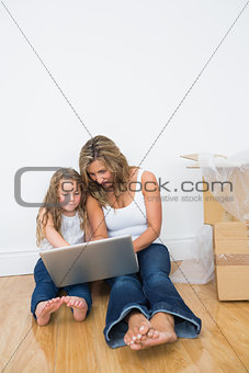 Daughter and mother looking at laptop
