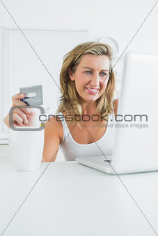 Smiling woman using laptop to shop online