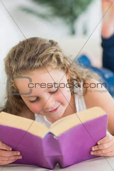 Girl resting on the sofa with book